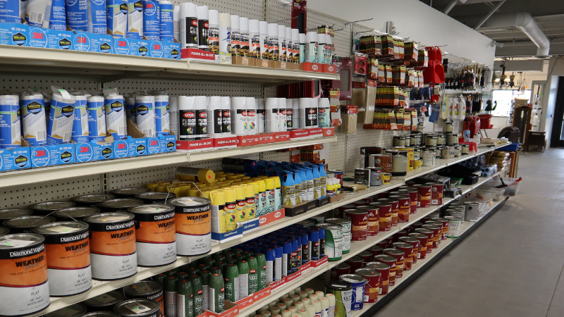 Selection of paint supplies on shelves.
