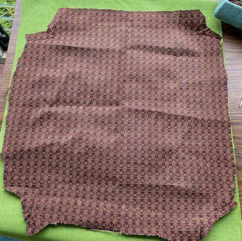 The old upholstery fabric laid on top of the new.