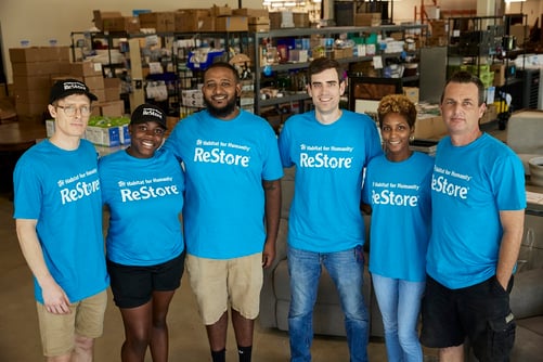 Group photo of six ReStore employees in blue shirts.