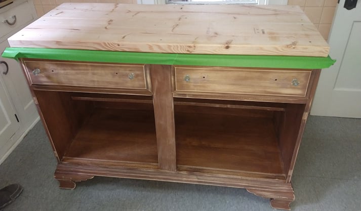 A buffet with new butcher block and green tape