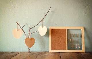 A bulletin board and tree with hearts made from building materials.