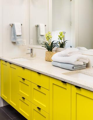 A remodeled counter with yellow cabinets.
