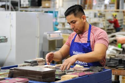 A ReStore volunteer sorting tiles.