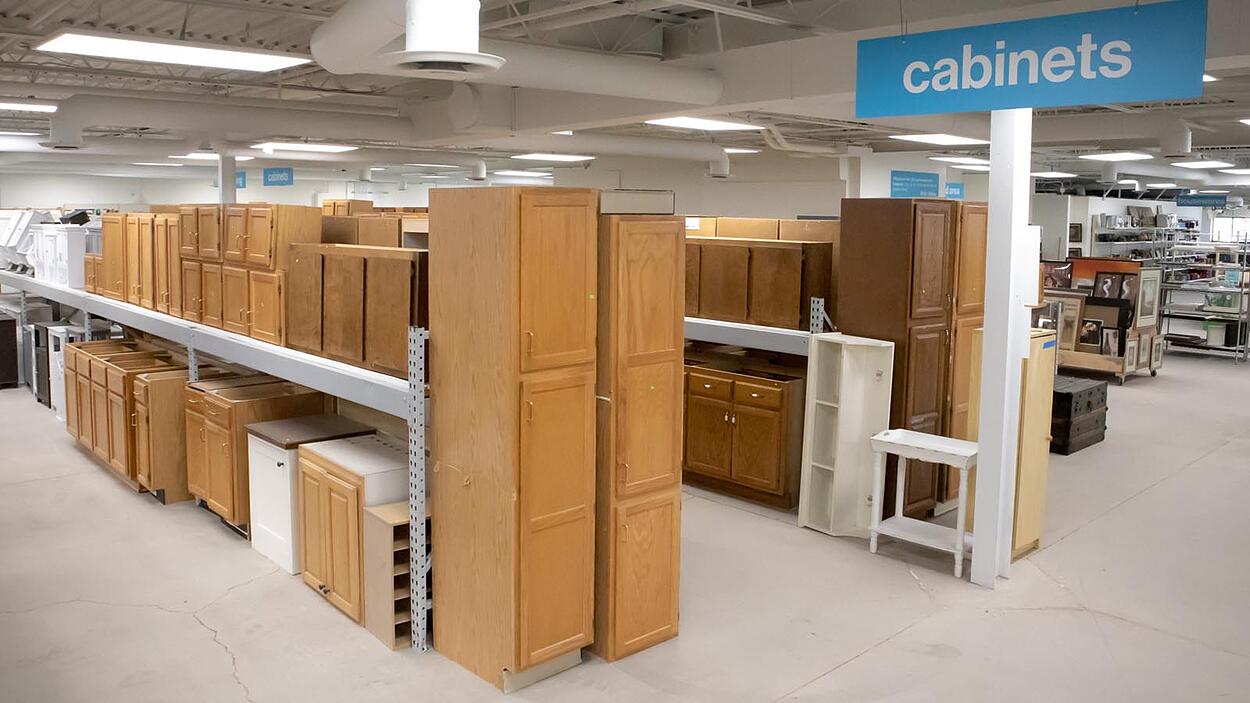 Cabinet section at ReStore with many wood cabinets on display.