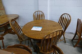Round, light brown table with chairs.