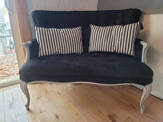 Upcycled black couch with white trim and black and white pillows