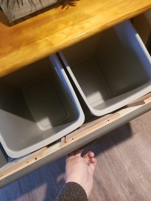 Table cupboards open to reveal laundry sorters