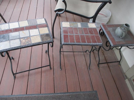 Two small patio table tops made with different colors of brick and tile