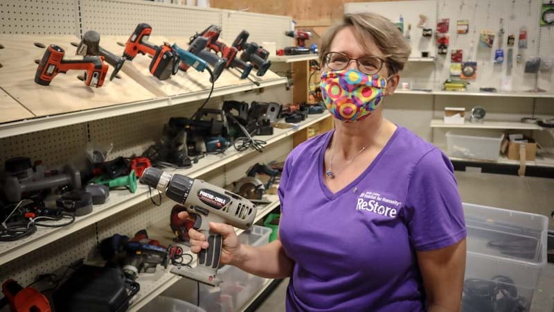 Diane working at ReStore, holding a power drill.