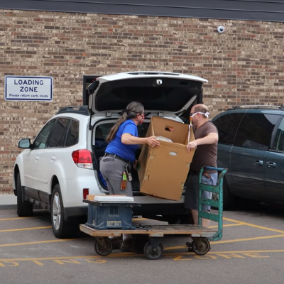two people loading a donation in a car at ReStore home improvement outlets