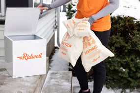 Ridwell worker picking up bags of donations from a front step