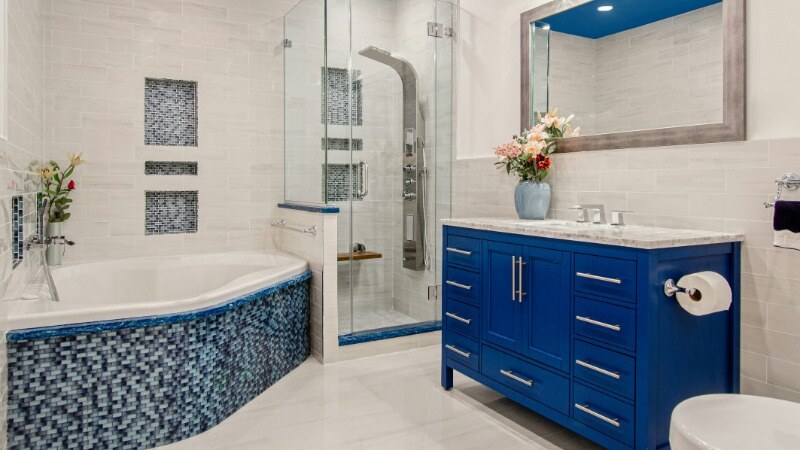 Modern bathroom with blue cabinets.