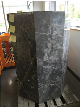 A tall, marble octagonal mystery item with sticky notes on it.