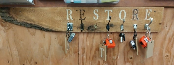 A handmade tape measure holder that says "ReStore."