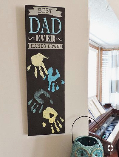 Wall decoration with hand prints, saying "Best Dad ever hands down."