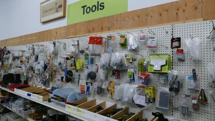 Shelves and a pegboard with tools for sale.