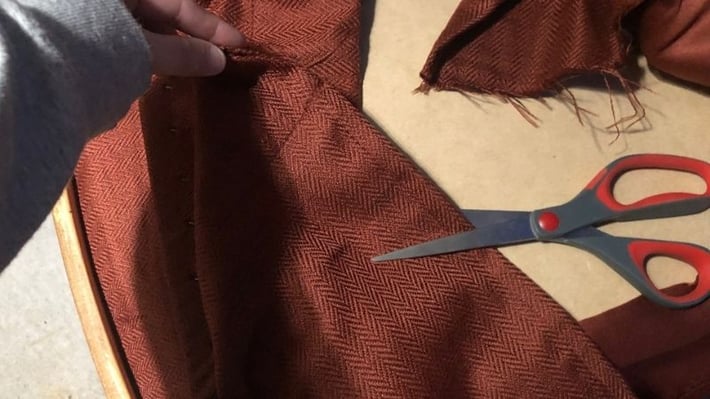 Cutting off excess fabric.