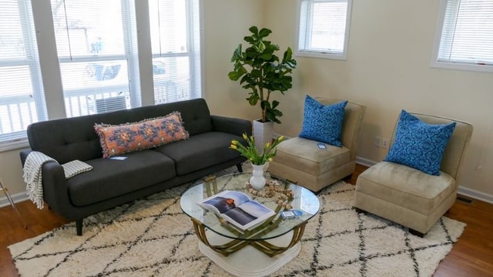 Living room with couch, chairs, rug, and coffee table.