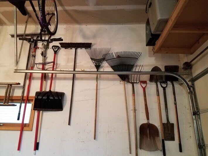 Yard tools hanging on a wall.