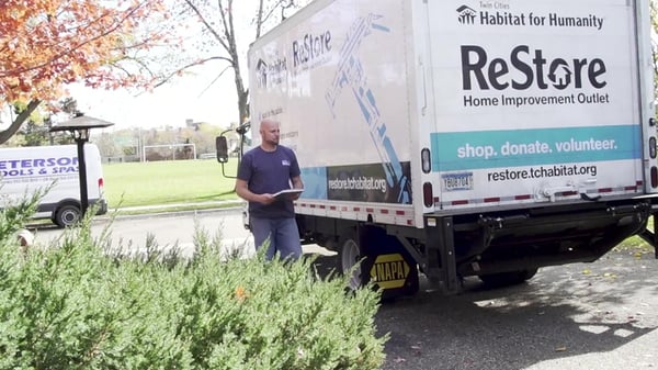 A ReStore staff member walking around a truck.