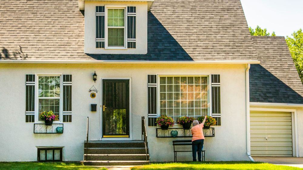 Person adding window boxes to home.