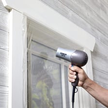 installing window insulation kit with hairdryer