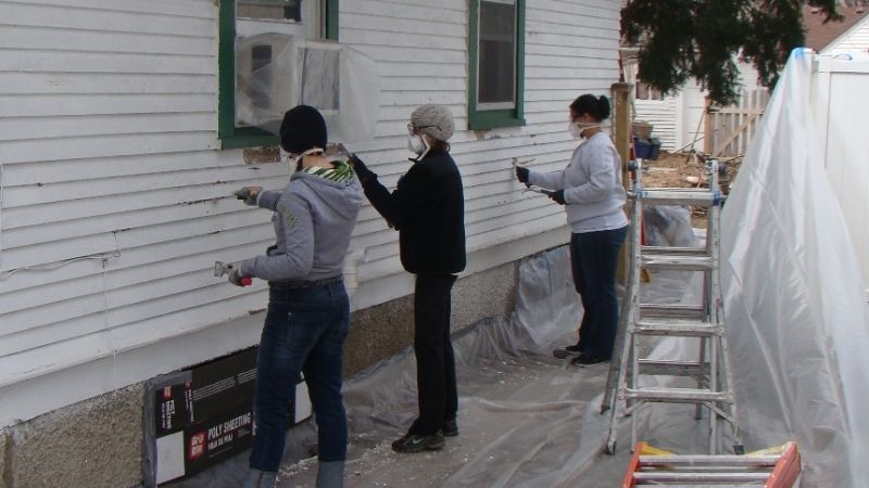 Volunteers painting a house.
