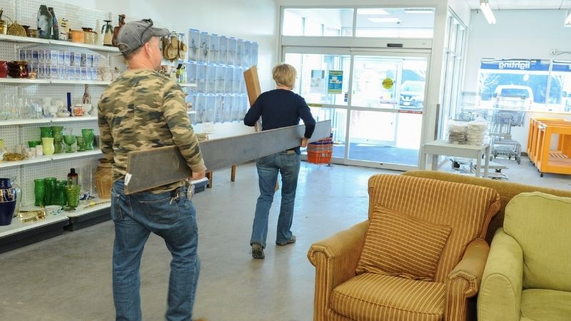 Customers carrying lumber out of the store.